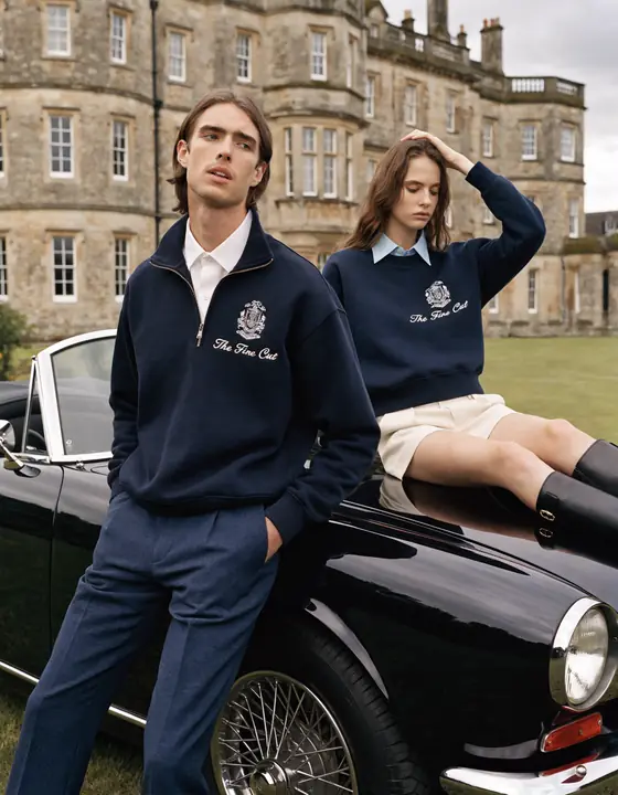Navy crest knitwear with a vintage roadster in front of a country estate