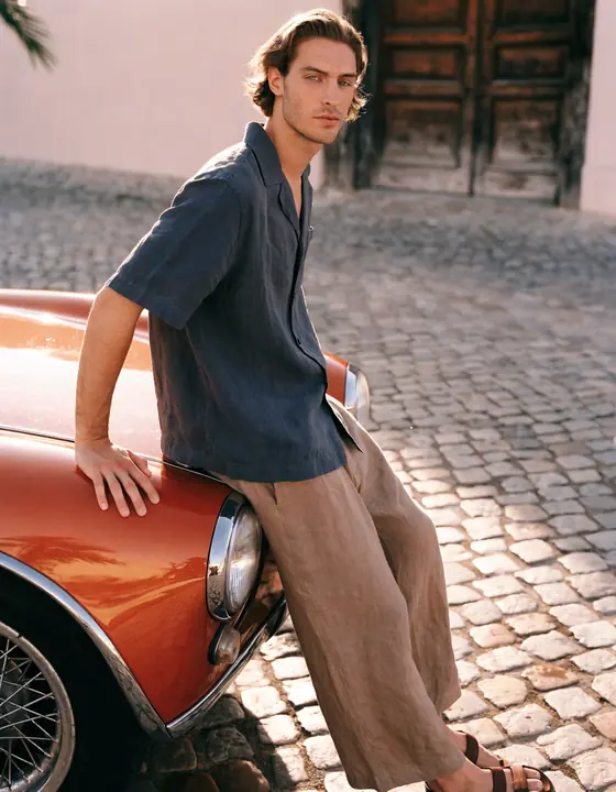 Navy linen camp shirt beside an orange classic car on cobblestones