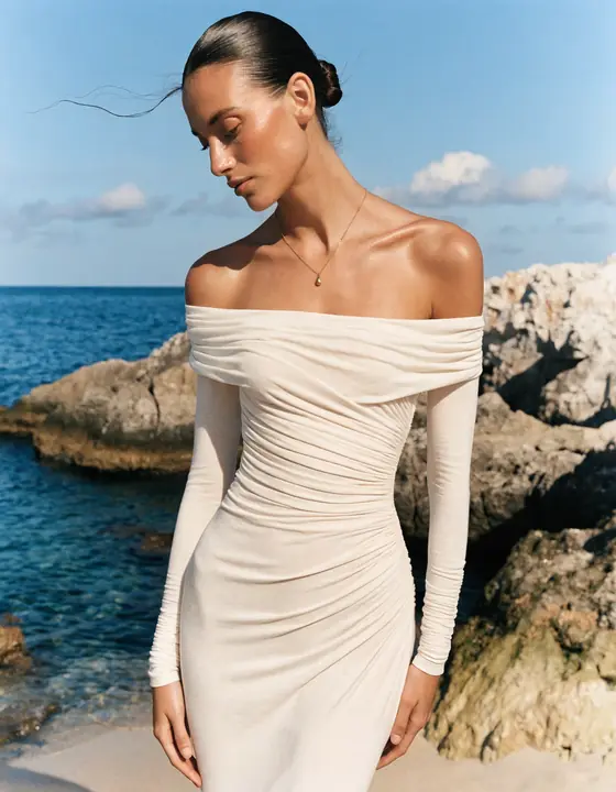 Off-shoulder ivory gown on coastal rocks